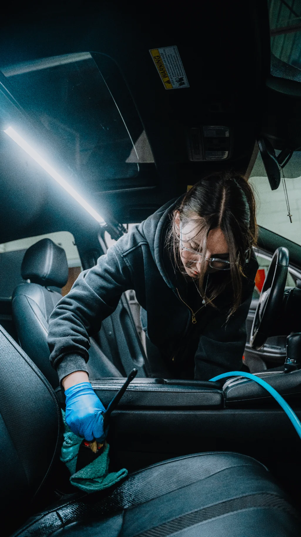Detailer working on the interior of a black SUV